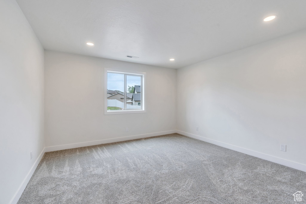 Carpeted spare room featuring recessed lighting