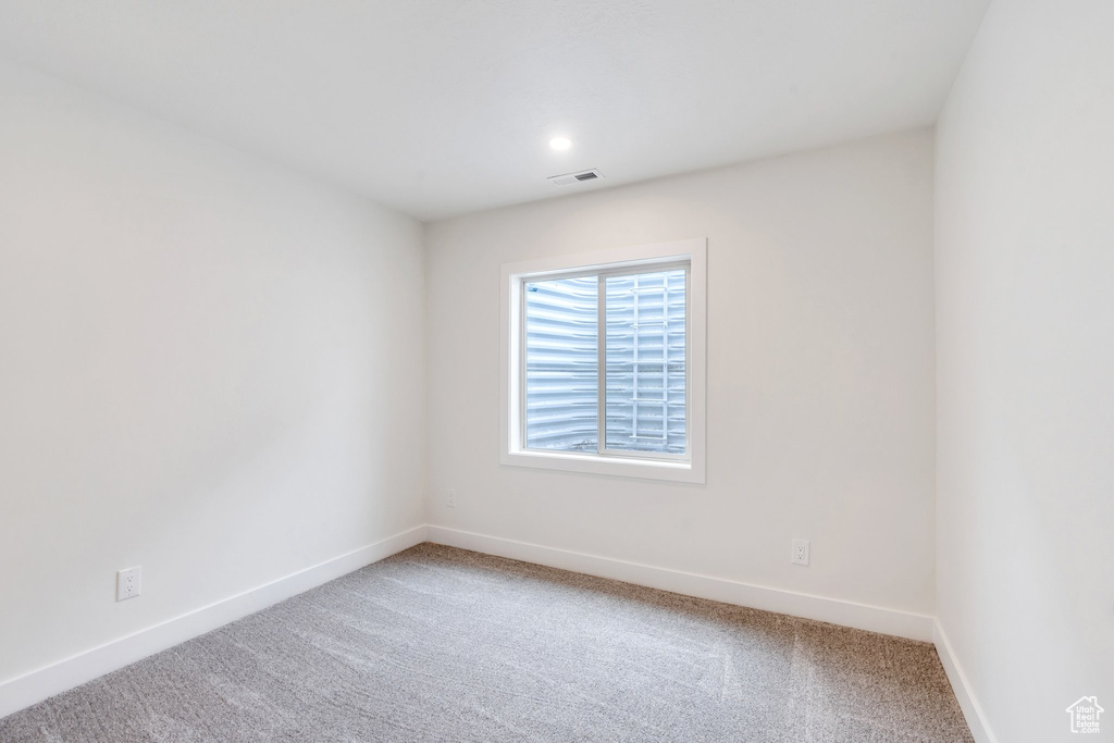 Carpeted empty room featuring baseboards and recessed lighting