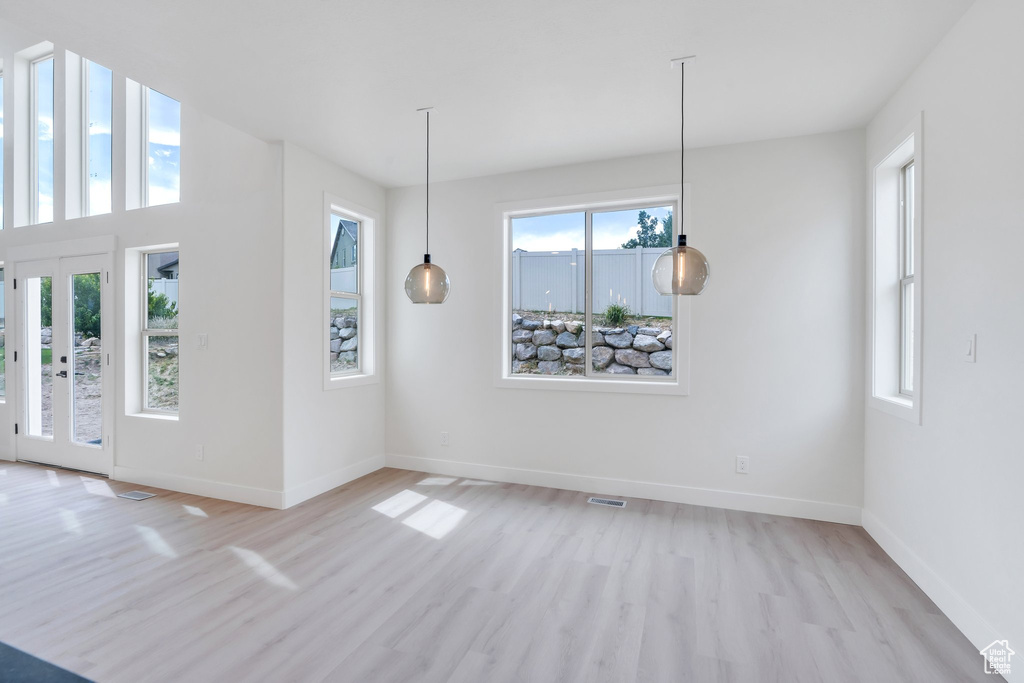 Unfurnished dining area with light wood-style flooring and baseboards