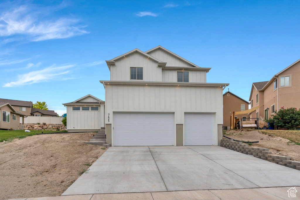 View of front facade featuring a garage and driveway