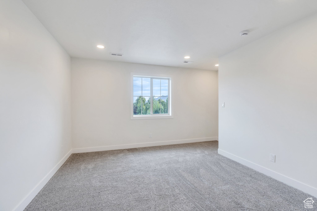 Carpeted empty room featuring recessed lighting and a smoke detector