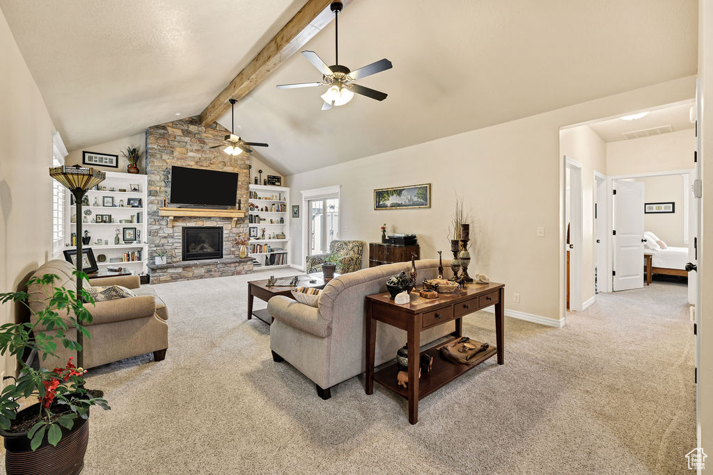 Living area with light carpet, a ceiling fan, and a stone fireplace