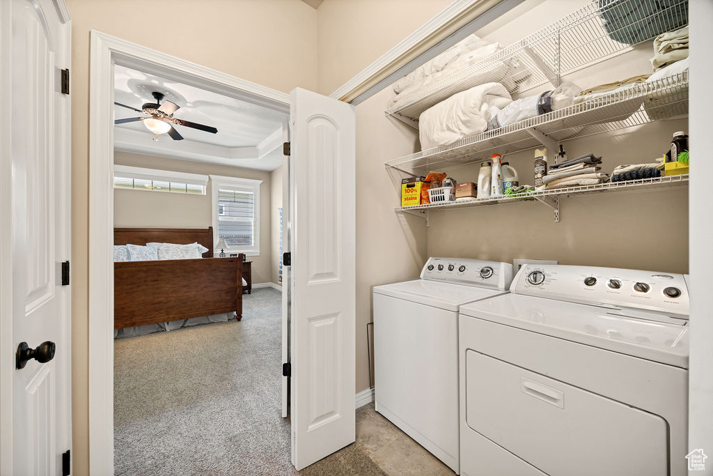 Laundry room featuring independent washer and dryer, a ceiling fan, and light colored carpet