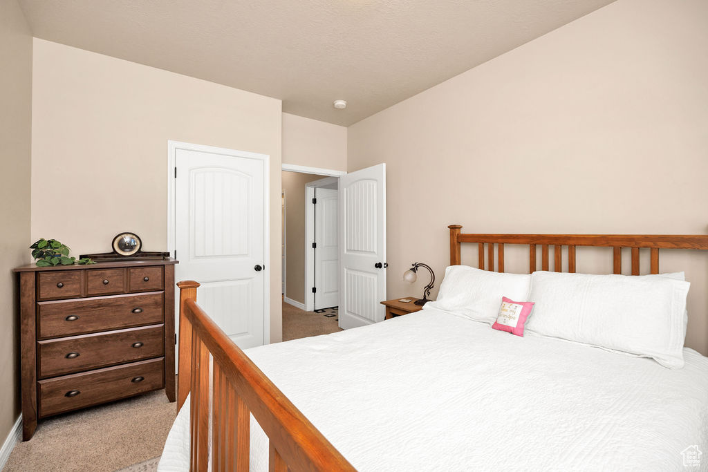 Bedroom with light carpet and baseboards
