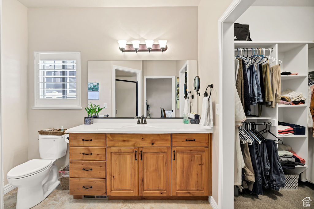 Full bathroom with vanity and a spacious closet