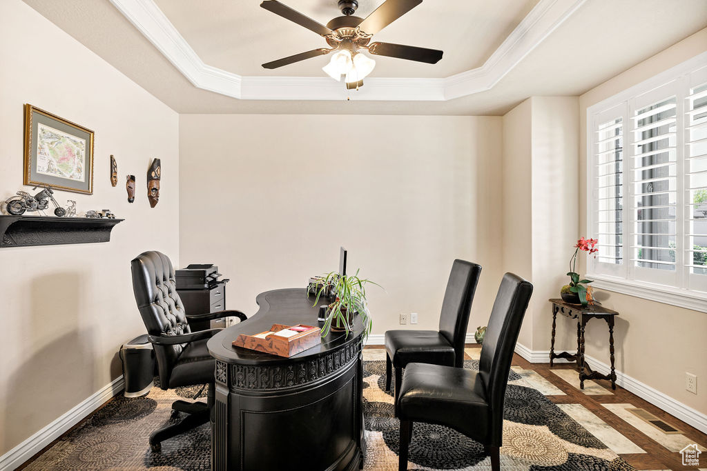 Home office with a raised ceiling, plenty of natural light, a ceiling fan, and crown molding