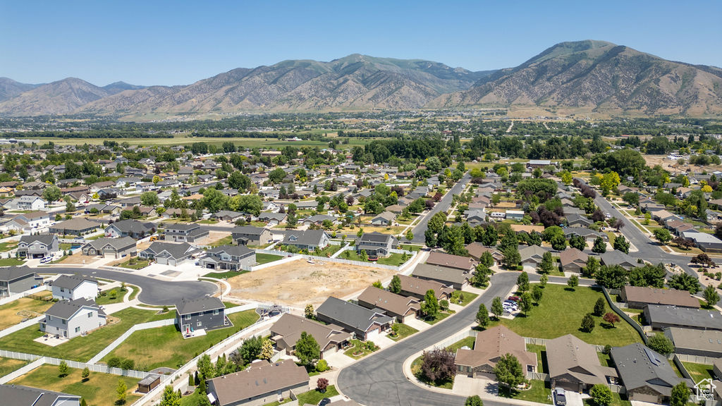 Aerial view of property and surrounding area with a mountainous background and nearby suburban area