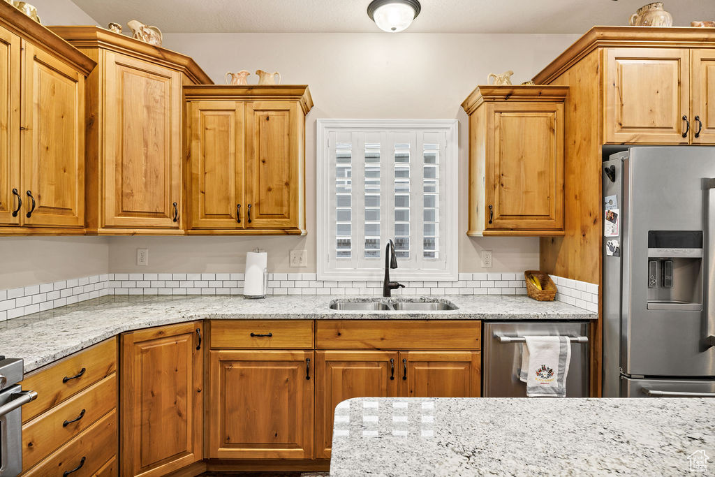 Kitchen featuring stainless steel refrigerator with ice dispenser and light stone countertops