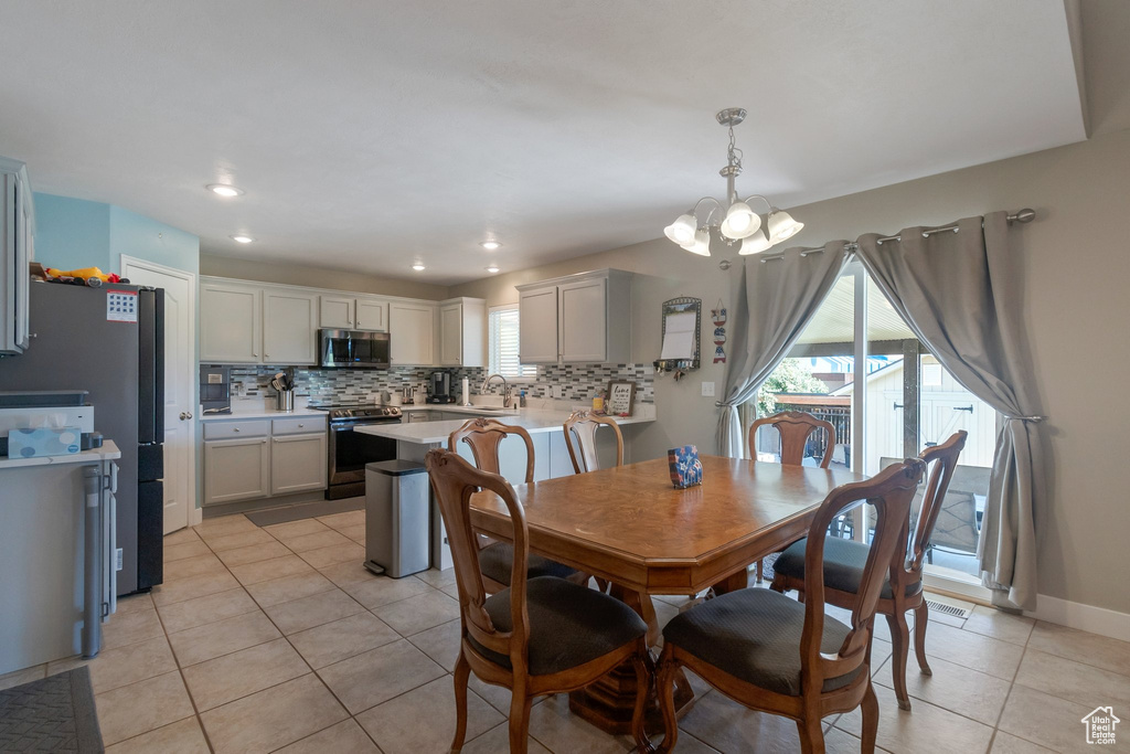 Dining space featuring a chandelier, light tile patterned floors, and recessed lighting