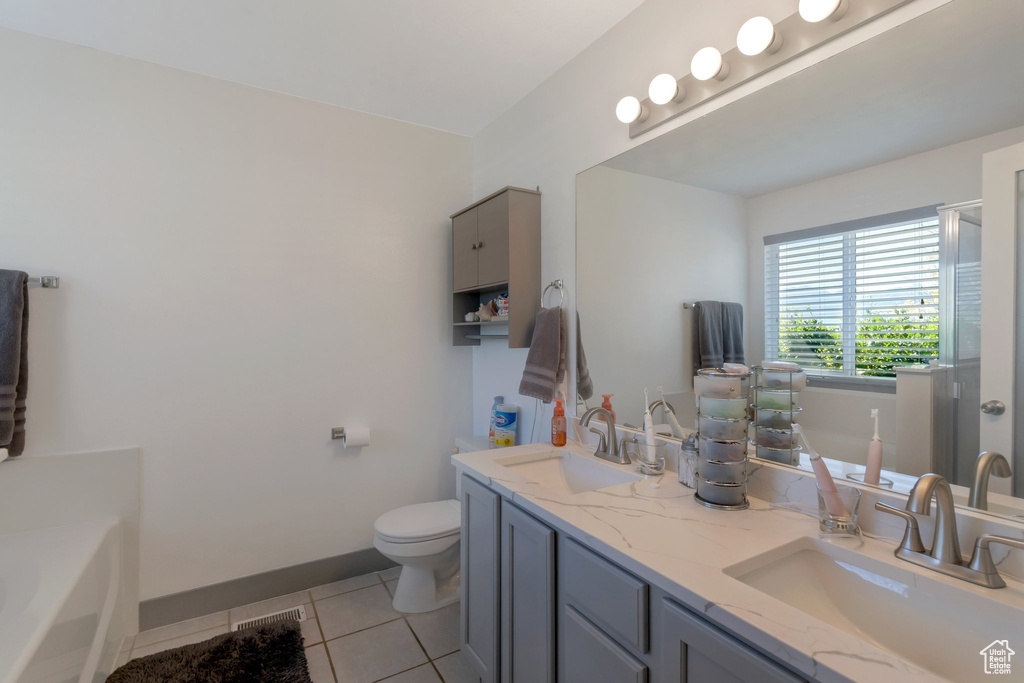Full bathroom featuring tile patterned floors, a bath, and double vanity