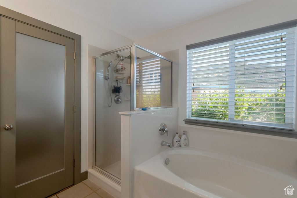 Full bathroom featuring a garden tub, a shower stall, and tile patterned floors