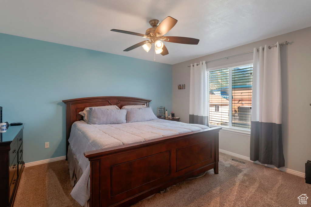 Carpeted bedroom with baseboards and a ceiling fan