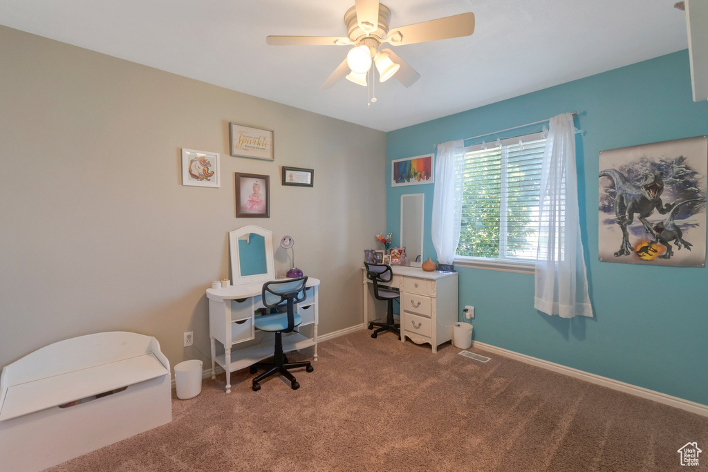Carpeted home office with ceiling fan and baseboards