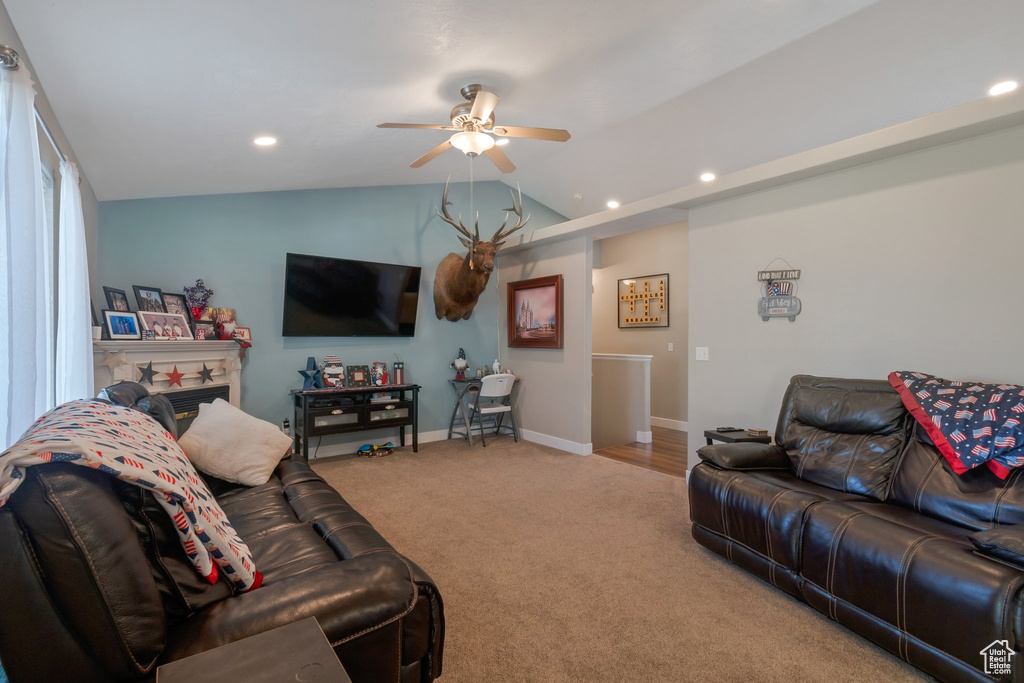 Carpeted living area featuring ceiling fan, recessed lighting, and lofted ceiling