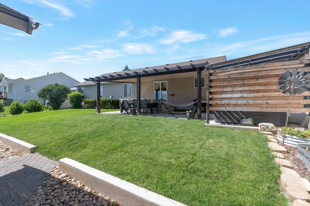 View of green lawn featuring a patio area and a pergola