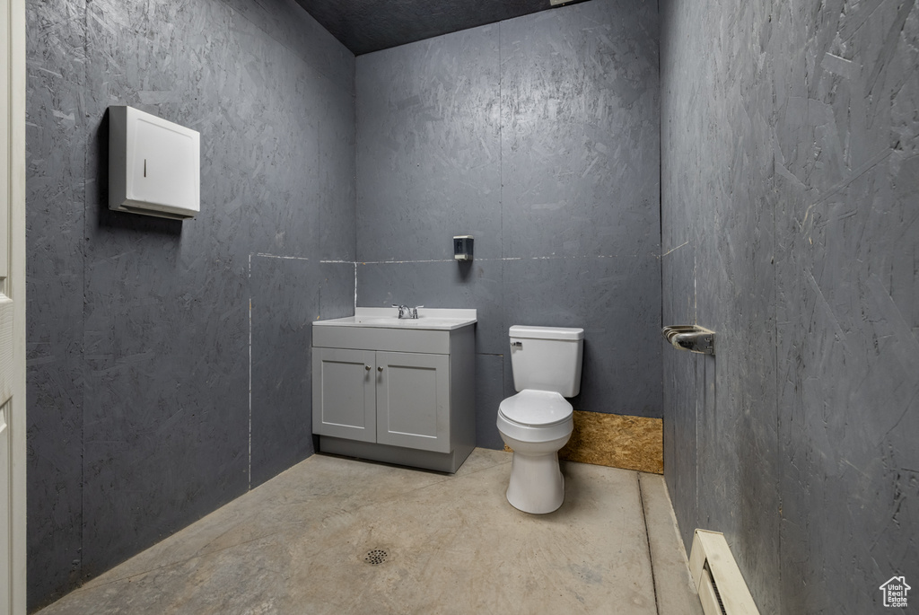 Half bath featuring baseboard heating and vanity
