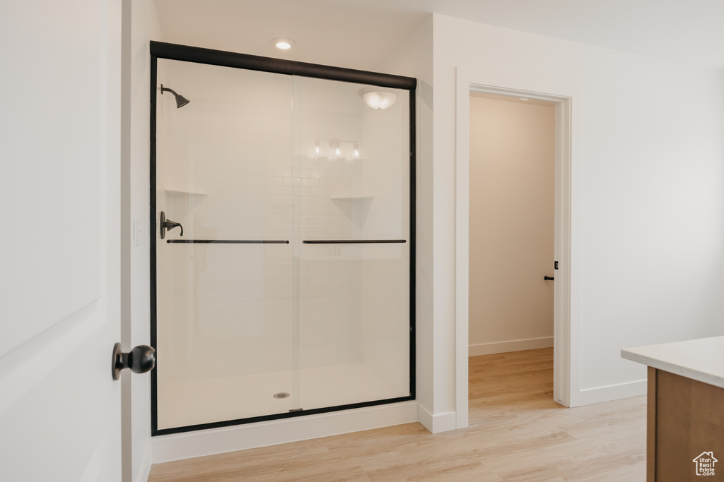 Full bath featuring a stall shower, wood finished floors, and vanity