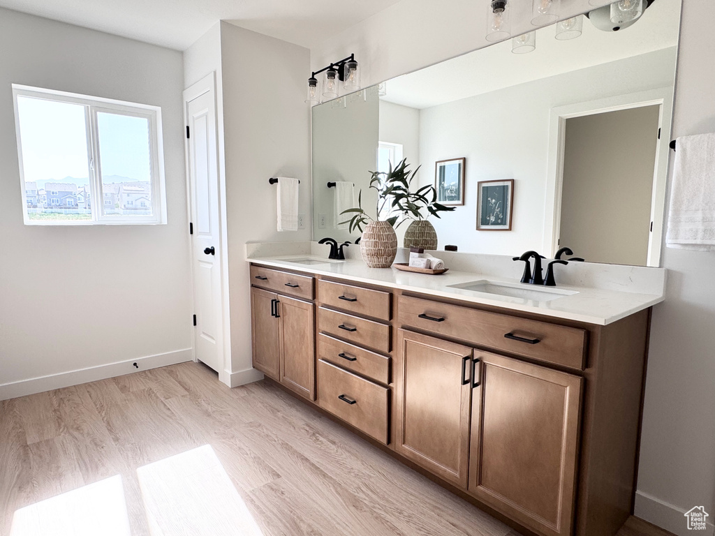 Full bath with double vanity and wood finished floors