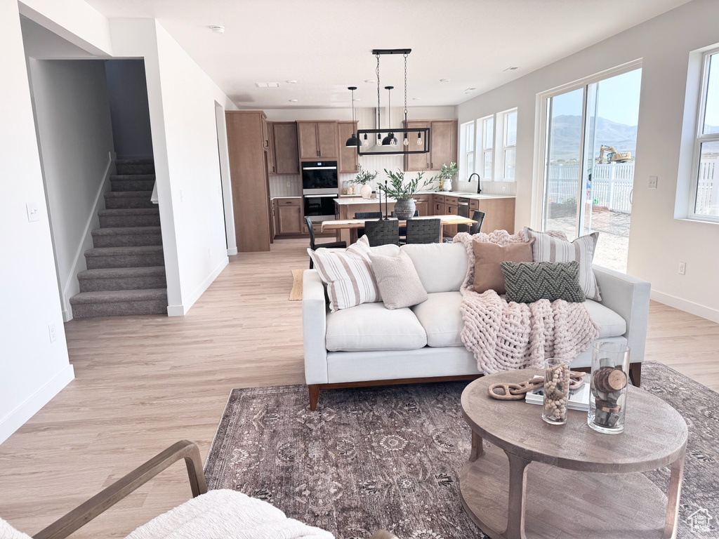 Living area featuring stairs, light wood-style flooring, and a mountain view