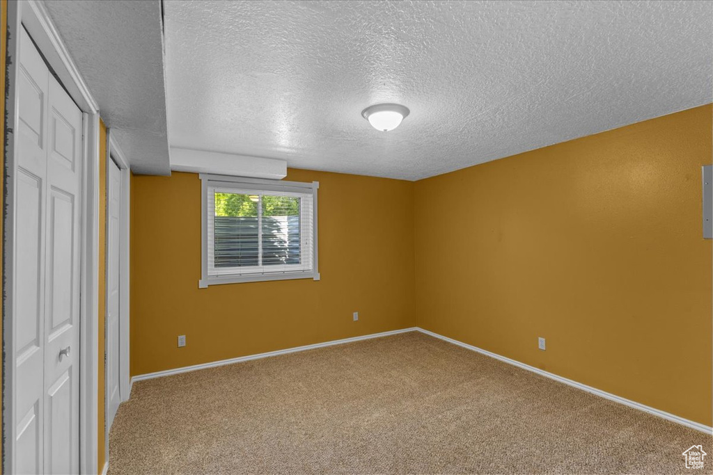 Unfurnished bedroom featuring a textured ceiling and carpet