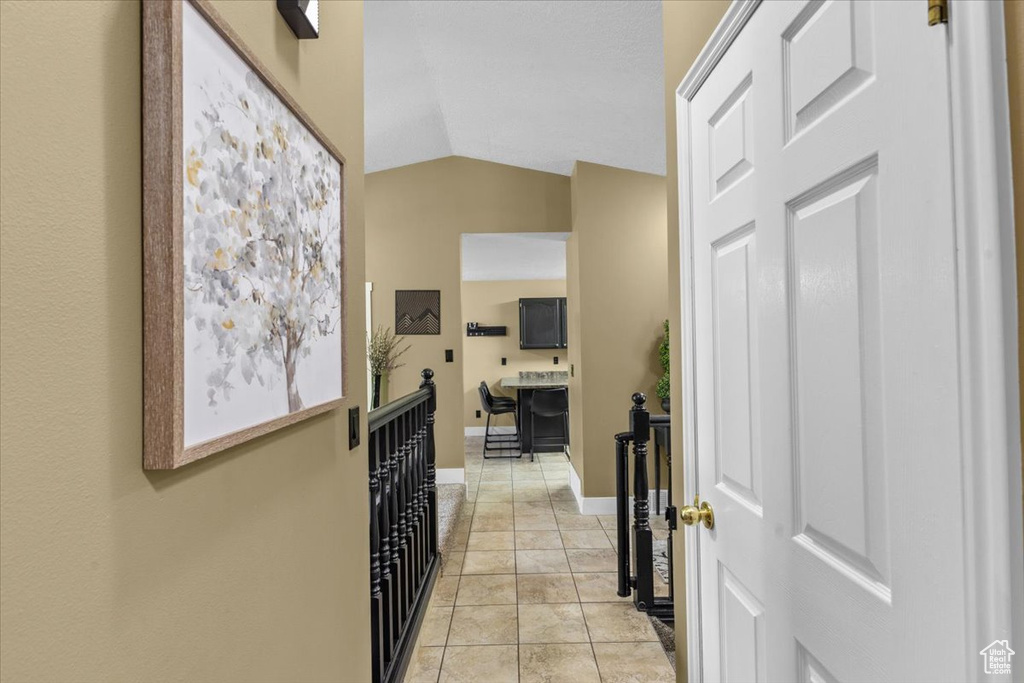 Hall with vaulted ceiling and baseboards