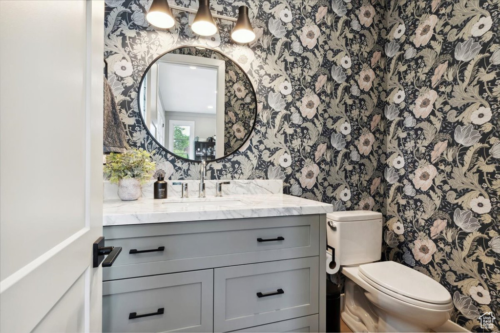 Bathroom with wallpapered walls and vanity