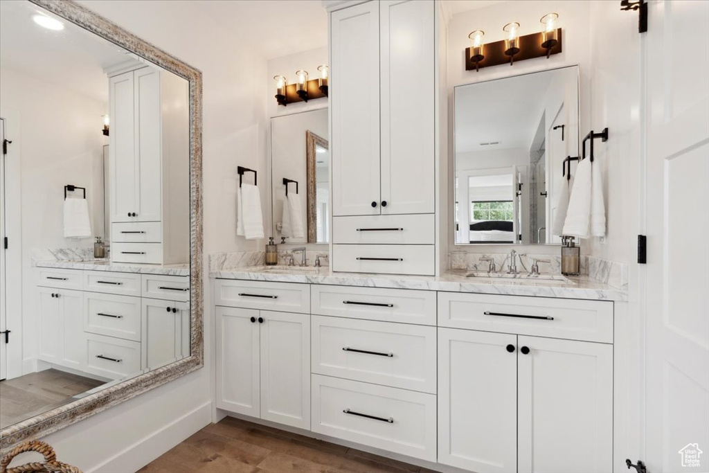 Full bath featuring double vanity and wood finished floors