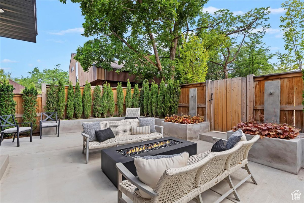 Fenced backyard with an outdoor fire pit and a patio area