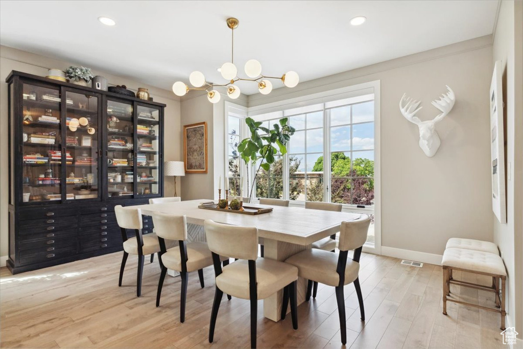 Dining space with a chandelier, light wood finished floors, and recessed lighting