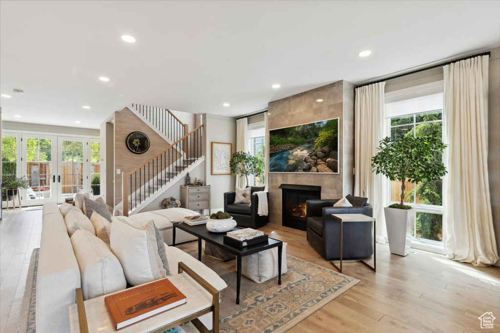 Living room with stairs, a tile fireplace, healthy amount of natural light, and recessed lighting