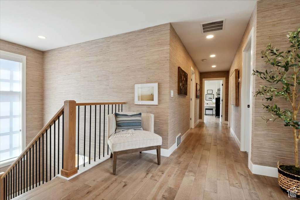 Hallway with wood-type flooring, an upstairs landing, and recessed lighting