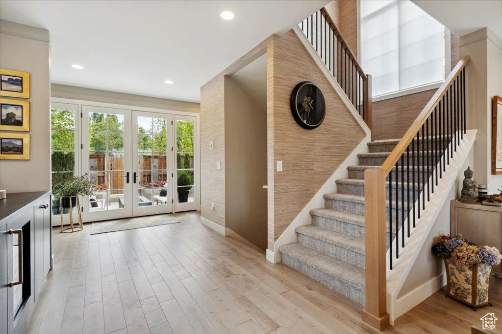 Stairs featuring french doors, wood finished floors, and recessed lighting