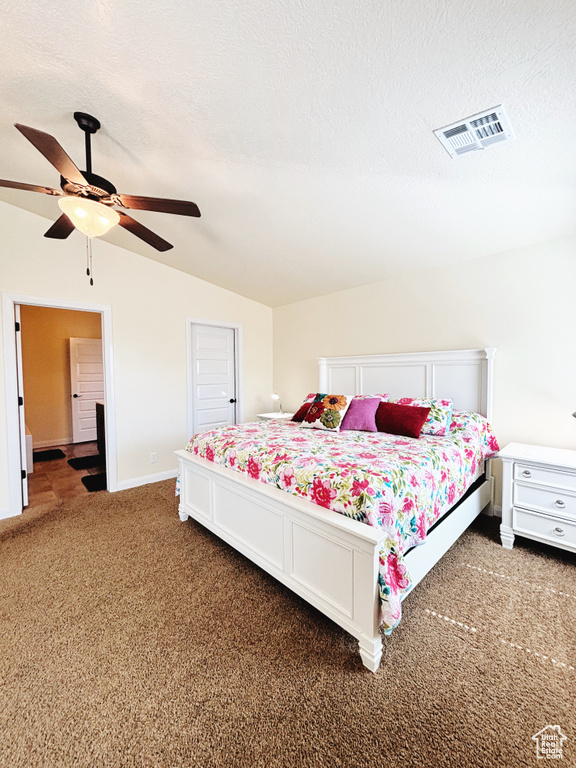 Carpeted bedroom with lofted ceiling, ceiling fan, and a textured ceiling