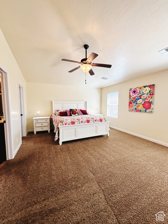 Bedroom with dark carpet and a ceiling fan