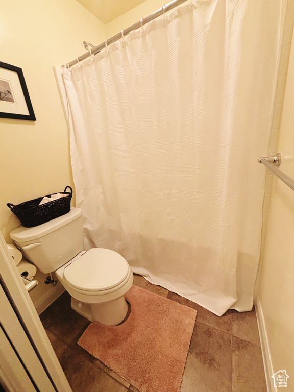 Full bathroom featuring toilet and a shower with curtain