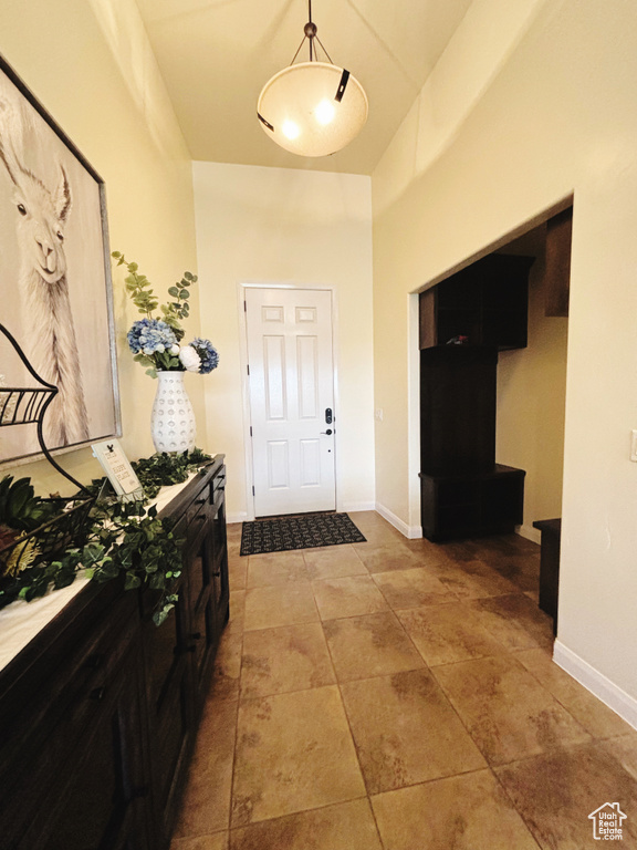 Entryway featuring baseboards and a towering ceiling