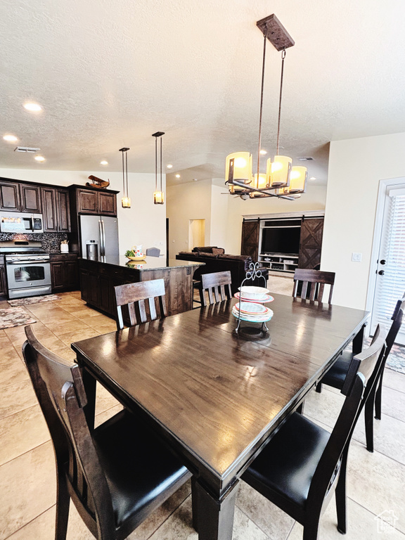 Dining area with a chandelier, recessed lighting, and a textured ceiling