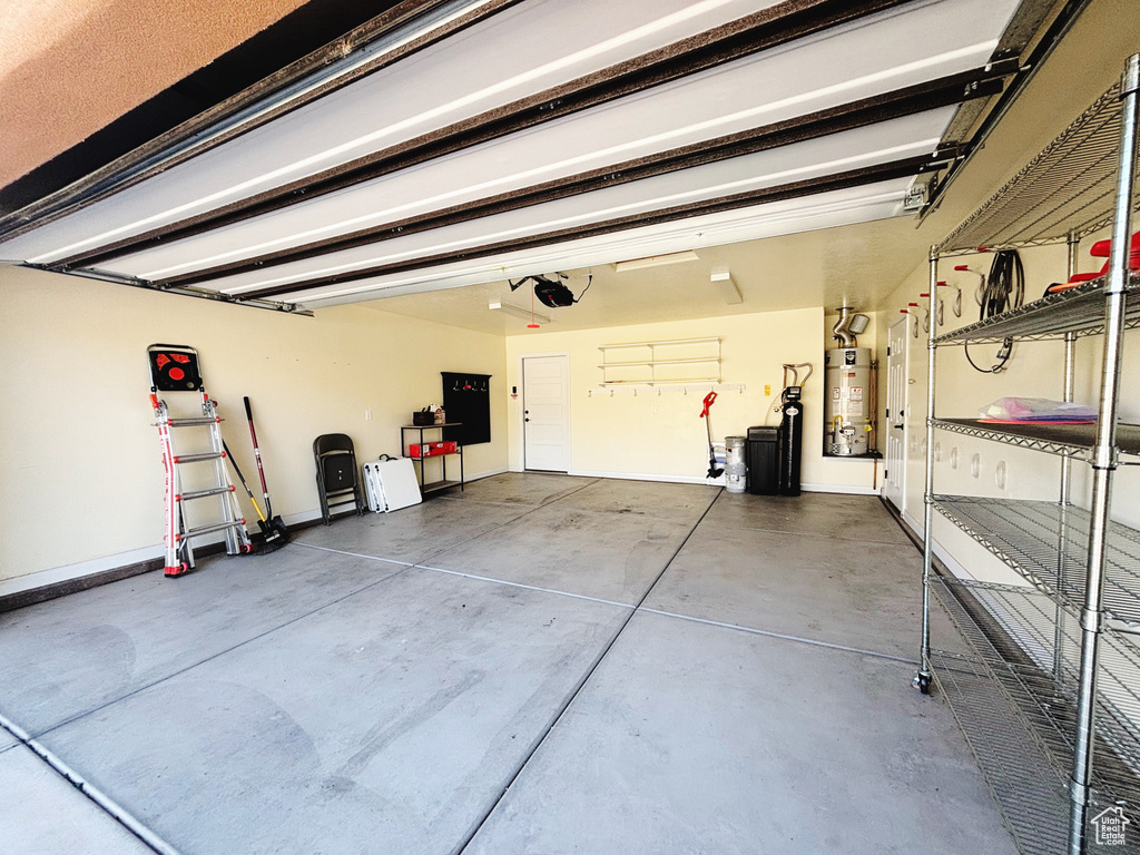 Garage featuring water heater and a garage door opener
