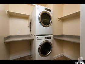 Laundry room featuring stacked washer / drying machine and baseboards
