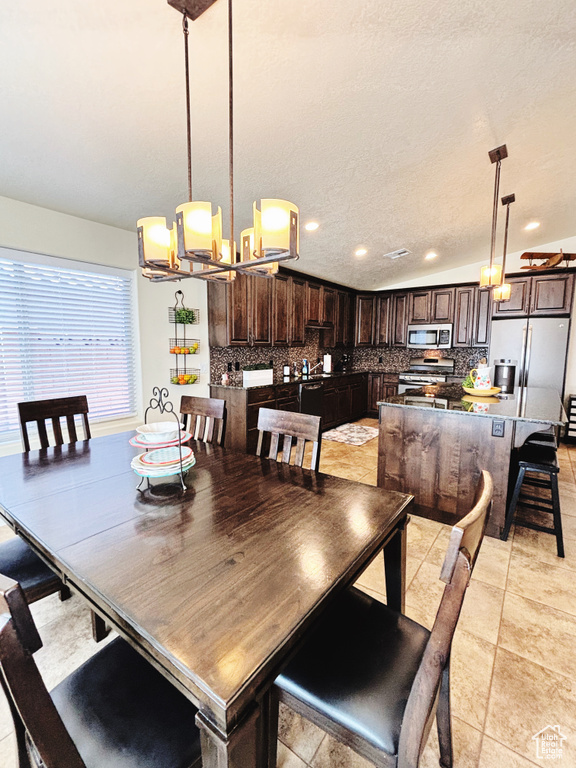 Dining area featuring a chandelier, recessed lighting, and a textured ceiling