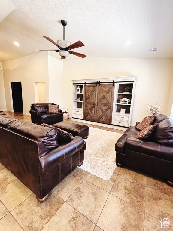 Living area with a ceiling fan, light tile patterned floors, a textured ceiling, recessed lighting, and lofted ceiling
