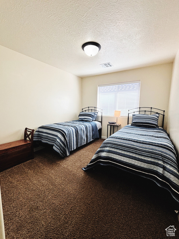 Carpeted bedroom with a textured ceiling