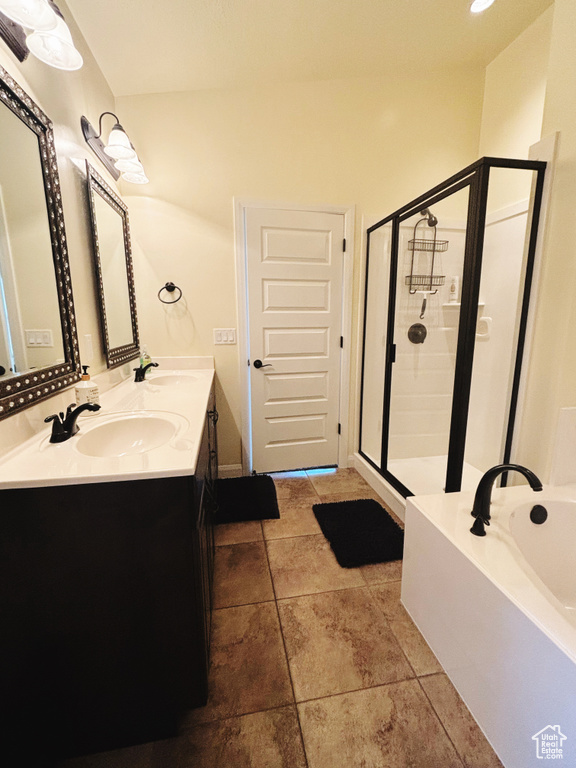 Bathroom featuring a bath, a stall shower, and double vanity