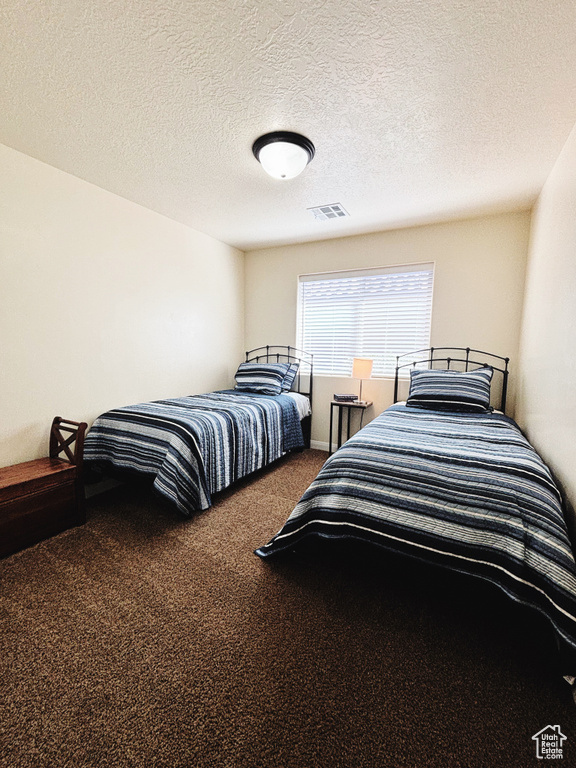 Bedroom with carpet flooring and a textured ceiling