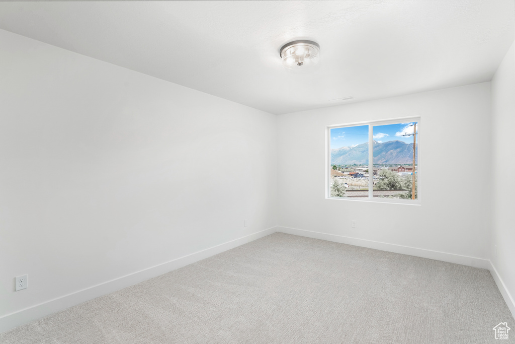Empty room featuring light carpet