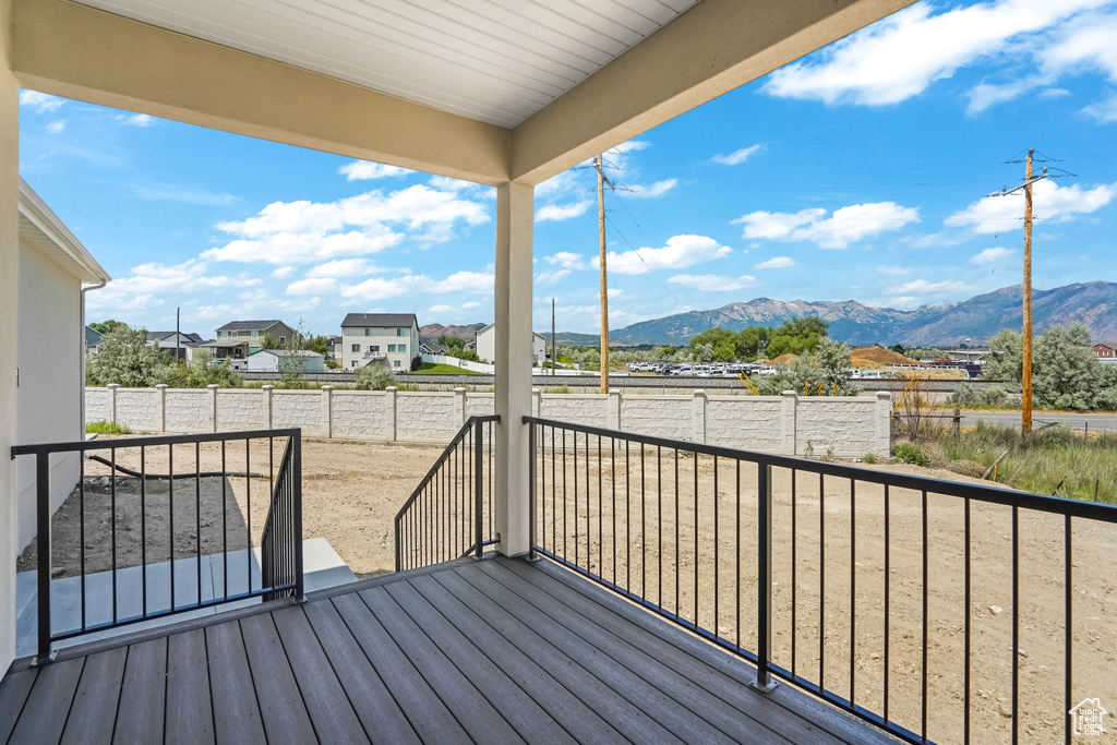 Wooden terrace featuring a mountain view, a fenced backyard, and a residential view