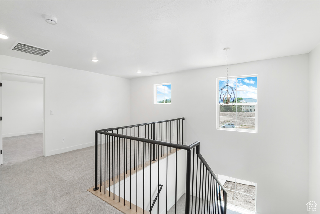 Corridor featuring an upstairs landing, carpet floors, a chandelier, and recessed lighting