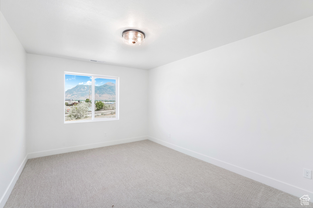 Unfurnished room with light colored carpet and baseboards