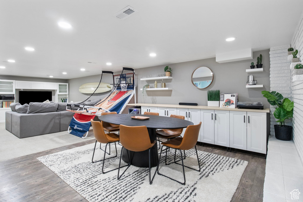 Dining space with wood finished floors and recessed lighting