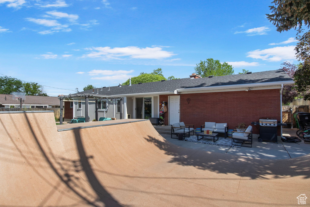 Rear view of house with an outdoor hangout area, a patio, and brick siding